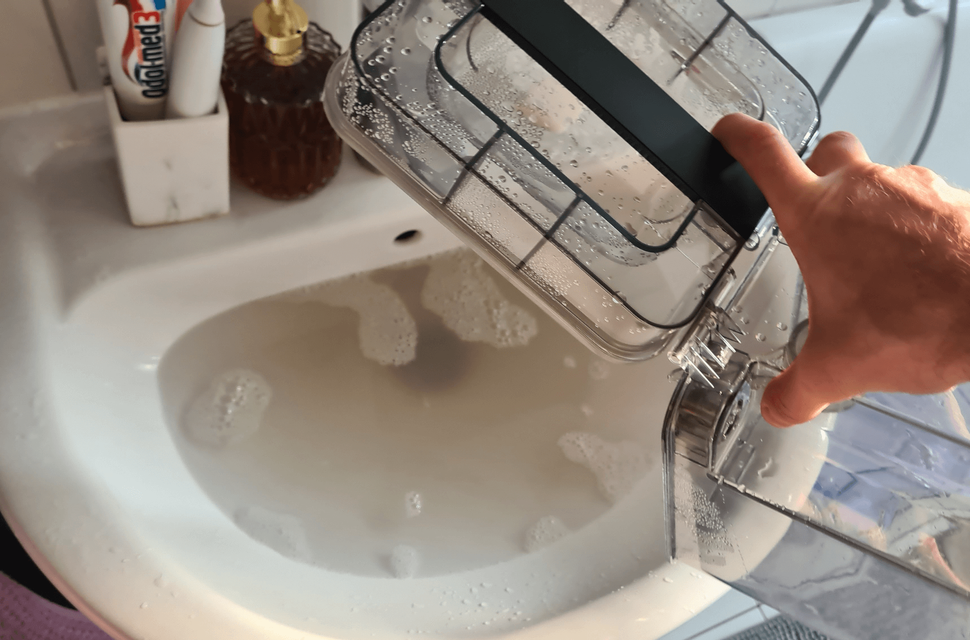 Der Schmutzwassertank der ECOVACS DEEBOT T20 OMNI Moppreinigungsstation wird ausgeleert.